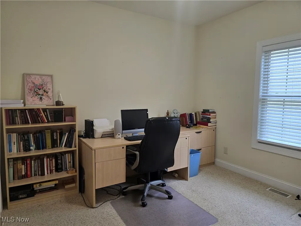 Office space with baseboards and light colored carpet