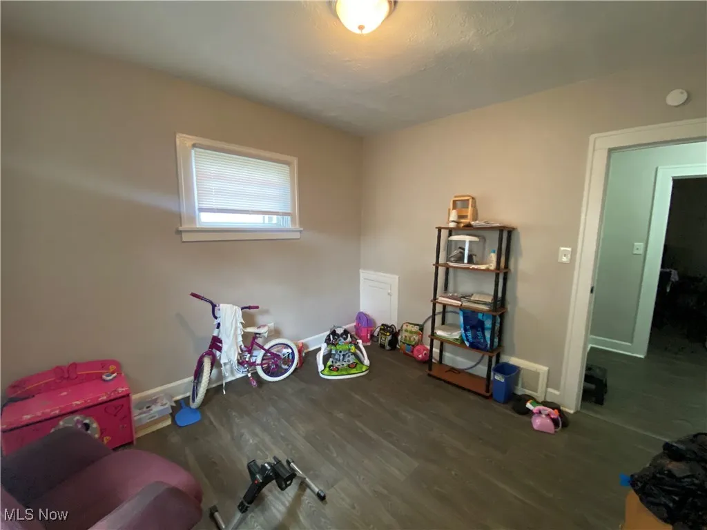 Recreation room featuring wood finished floors and baseboards
