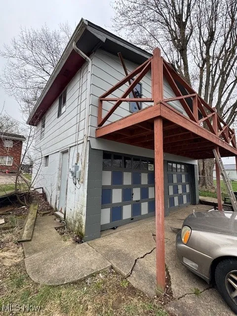 View of side of property with concrete driveway and a garage