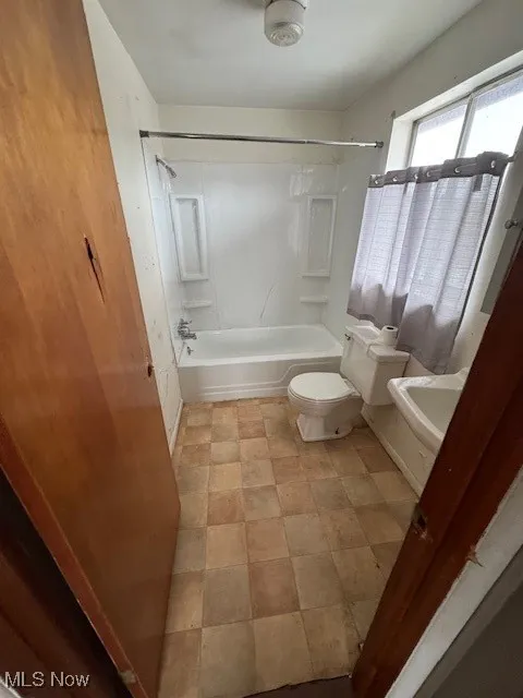Bathroom featuring toilet and shower / bathtub combination