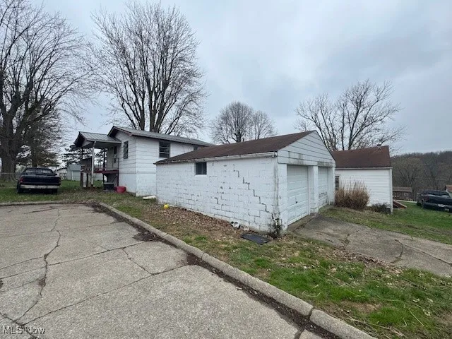 View of property exterior featuring a garage, and concrete block siding
