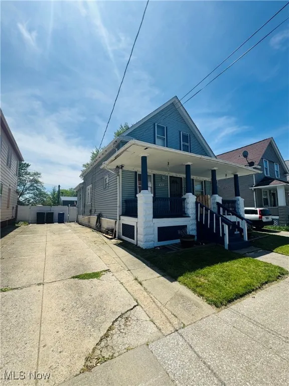 Bungalow with covered porch, driveway, and fence