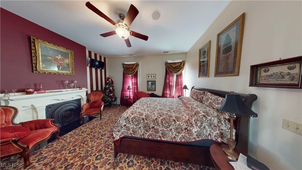 Carpeted bedroom featuring ceiling fan