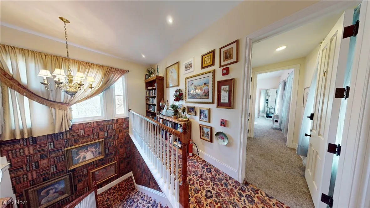 Stairway with an inviting chandelier and carpet