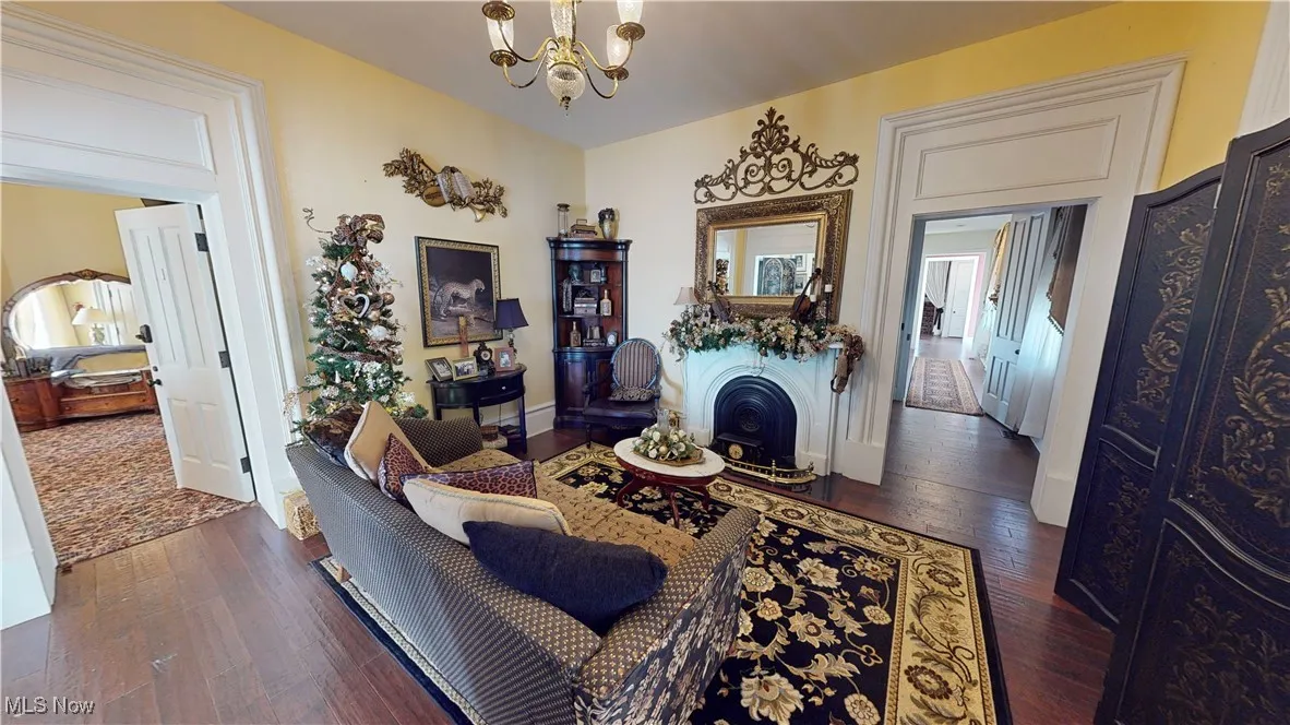 Living room with an inviting chandelier and dark hardwood / wood-style flooring