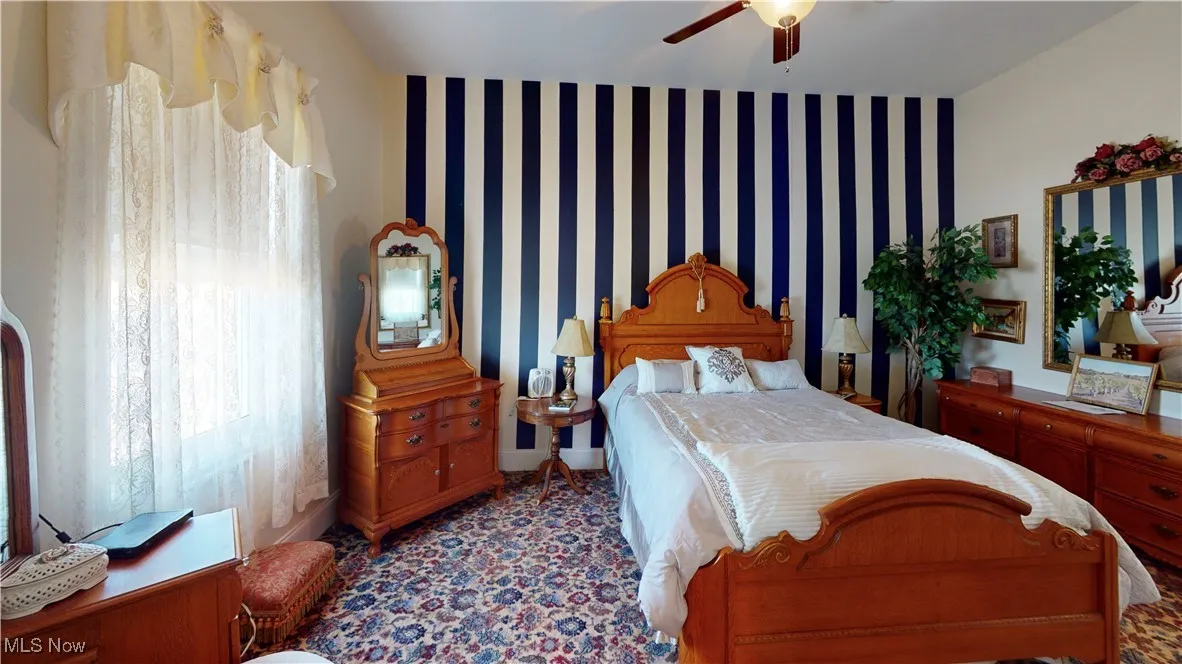 Bedroom with ceiling fan and multiple windows