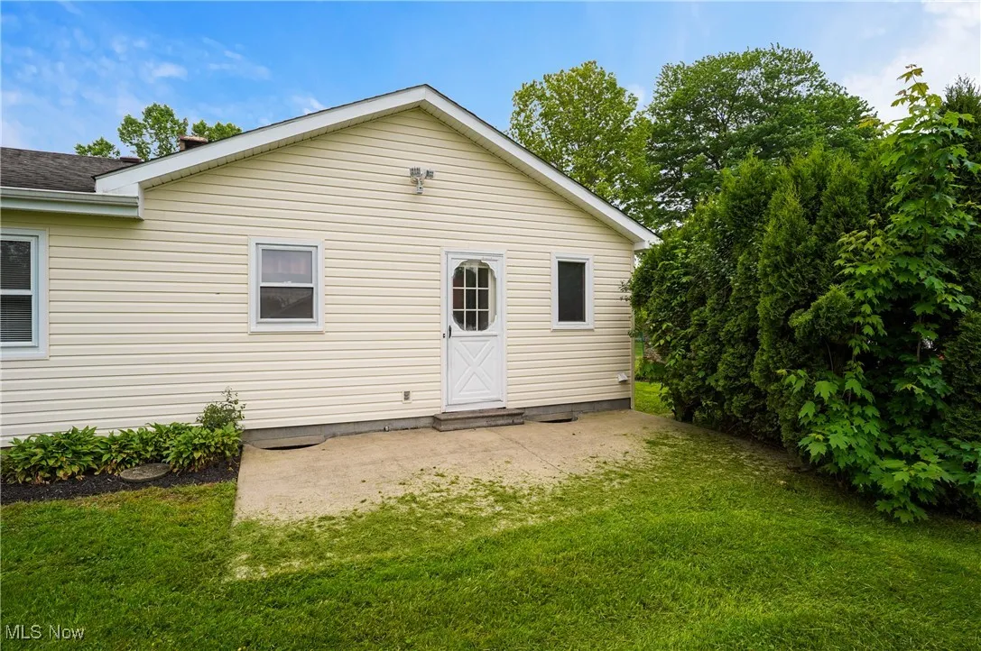 Rear view of property featuring a yard and a shingled roof