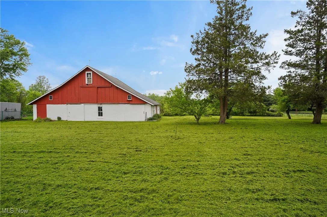 View of green lawn with a barn and an outbuilding