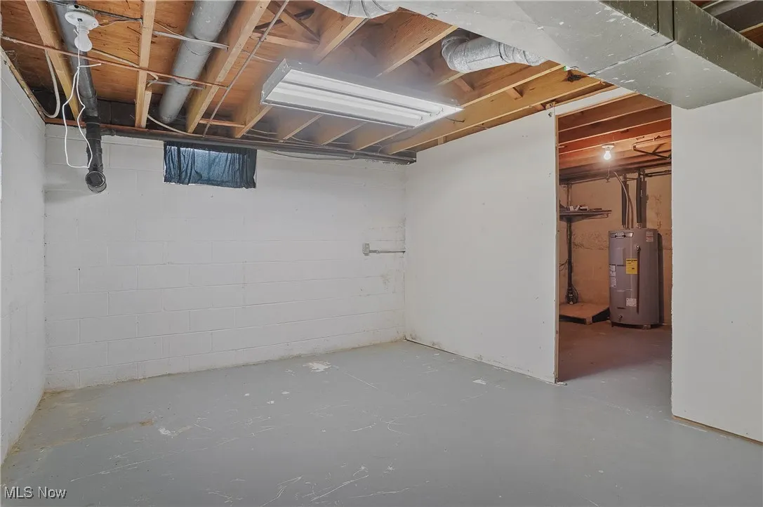 Unfinished below grade area featuring water heater
