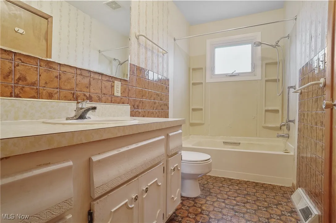 Full bath with shower / tub combination, toilet, and vanity