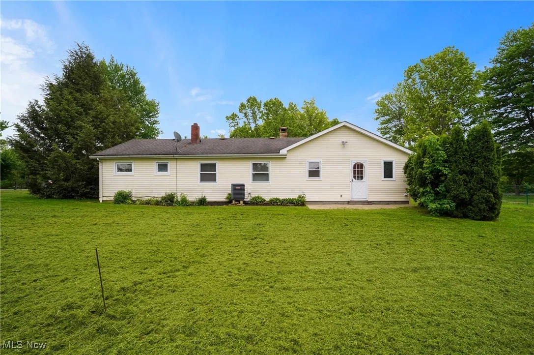 Rear view of property featuring a yard, a chimney, and a patio