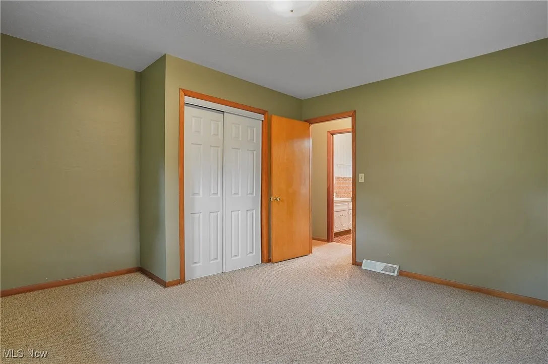 Unfurnished bedroom featuring carpet floors, a closet, and baseboards