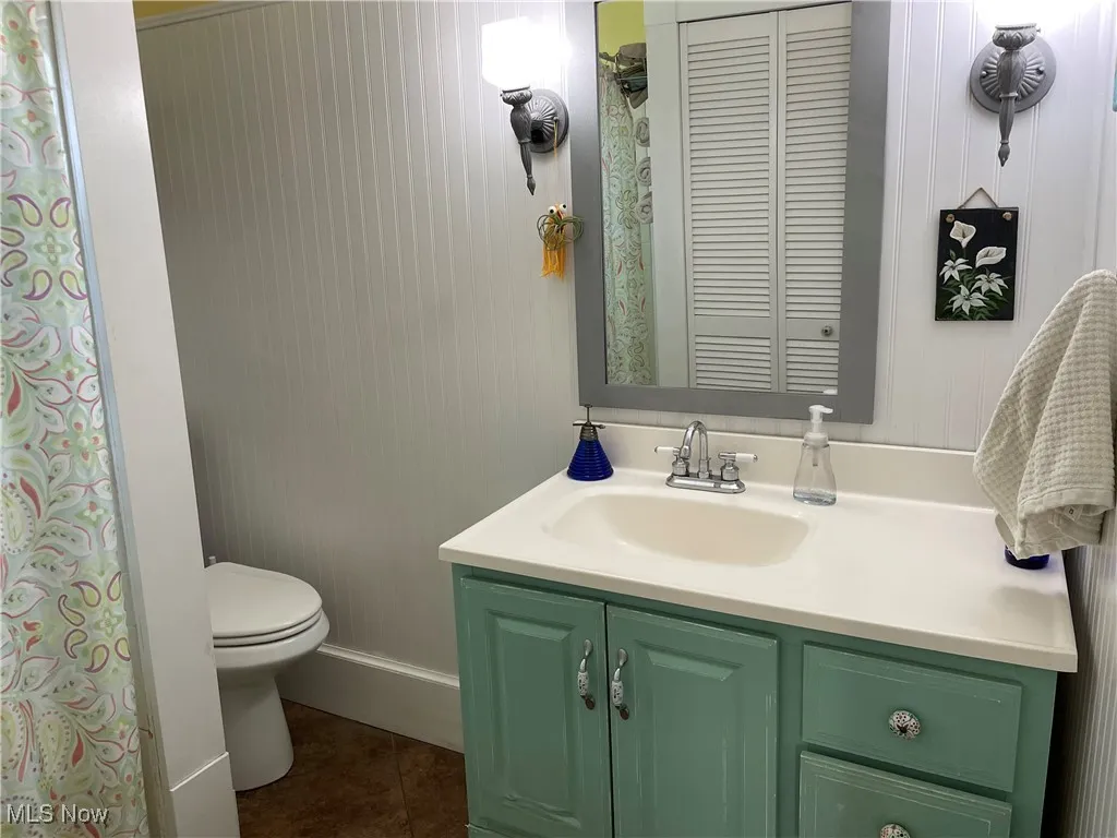 Bathroom featuring tile patterned flooring, vanity, and toilet