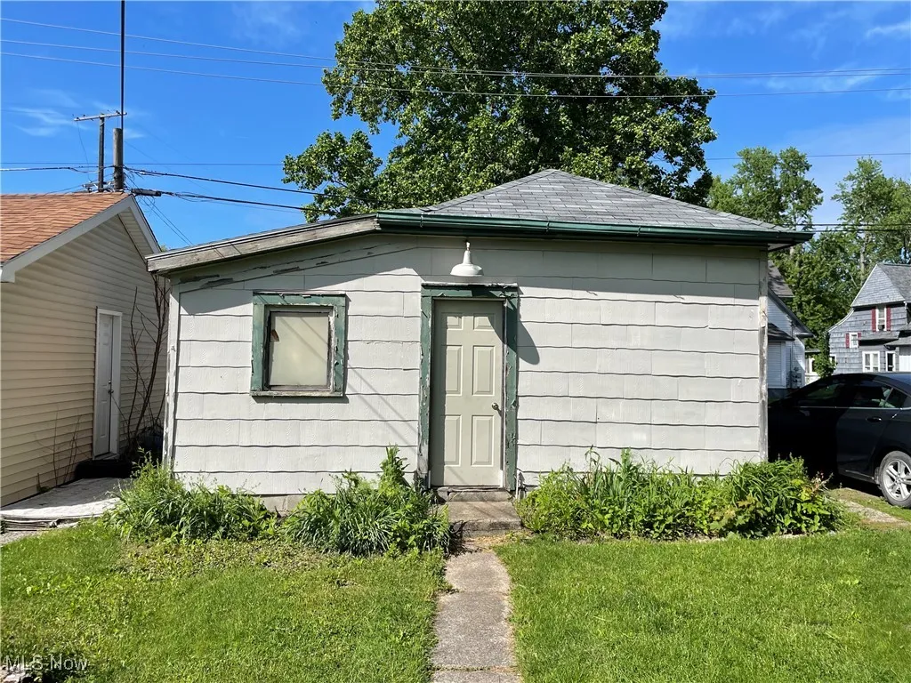 View of front facade featuring a front lawn and roof with shingles