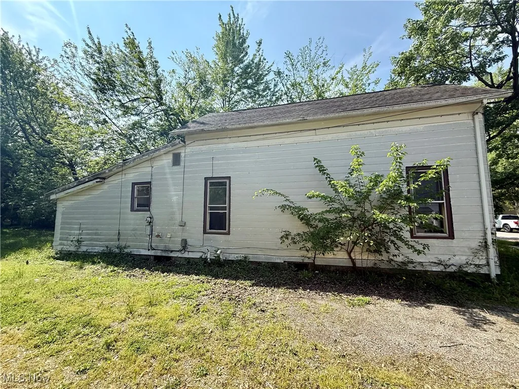 View of side of home featuring a lawn