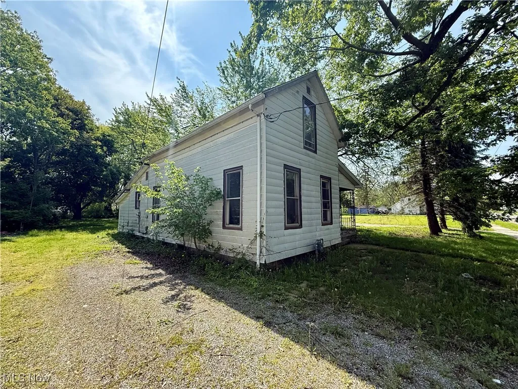 View of side of property with a lawn