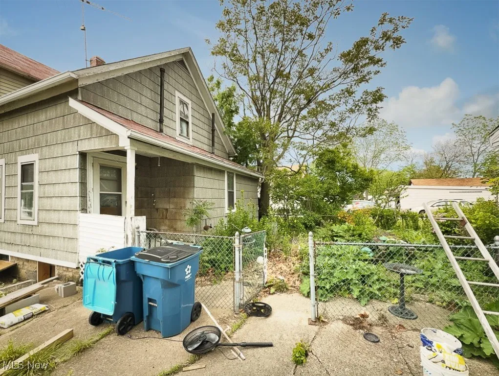 View of side of home with fence and a chimney