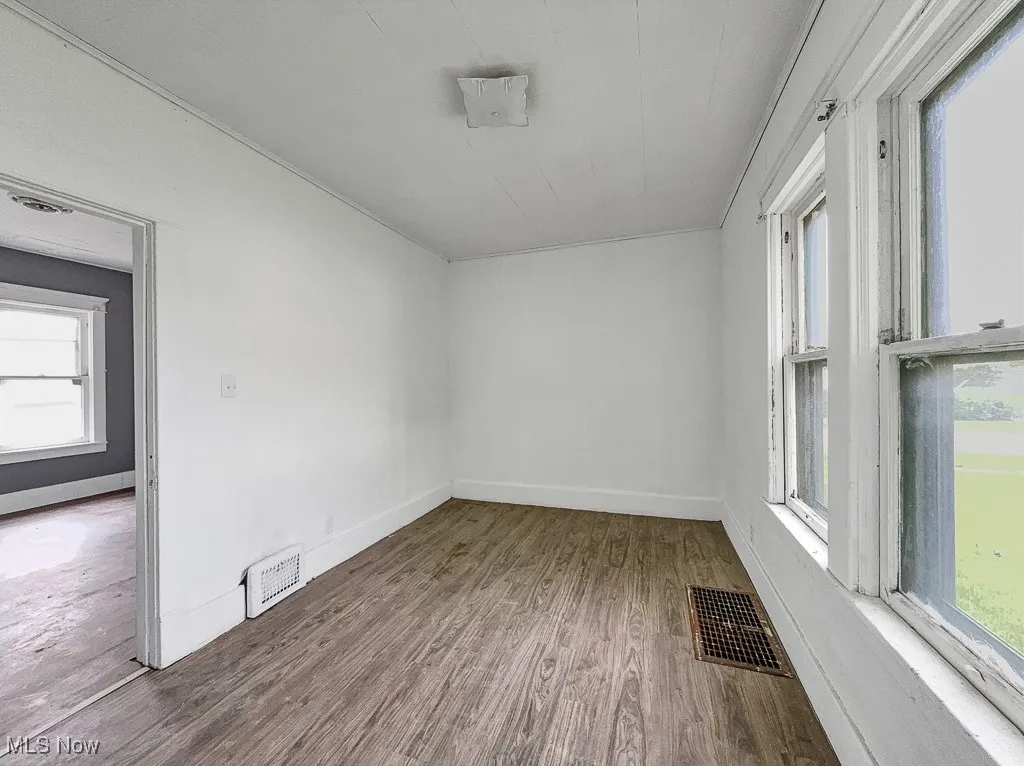 Empty room featuring wood finished floors and baseboards