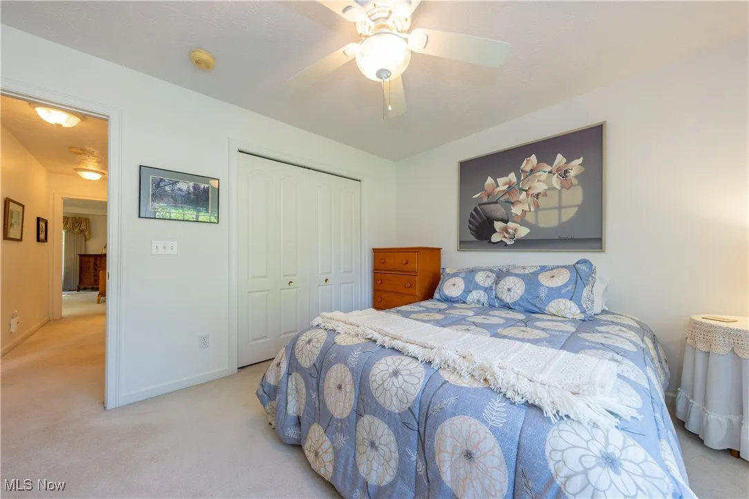 Carpeted bedroom featuring a closet, baseboards, and ceiling fan