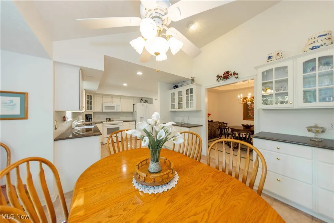 Dining area with a ceiling fan and high vaulted ceiling
