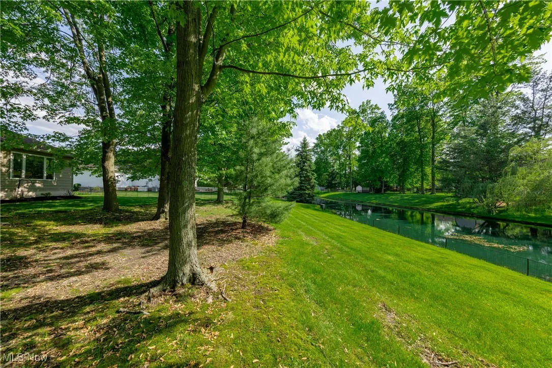 View of green lawn featuring a water view