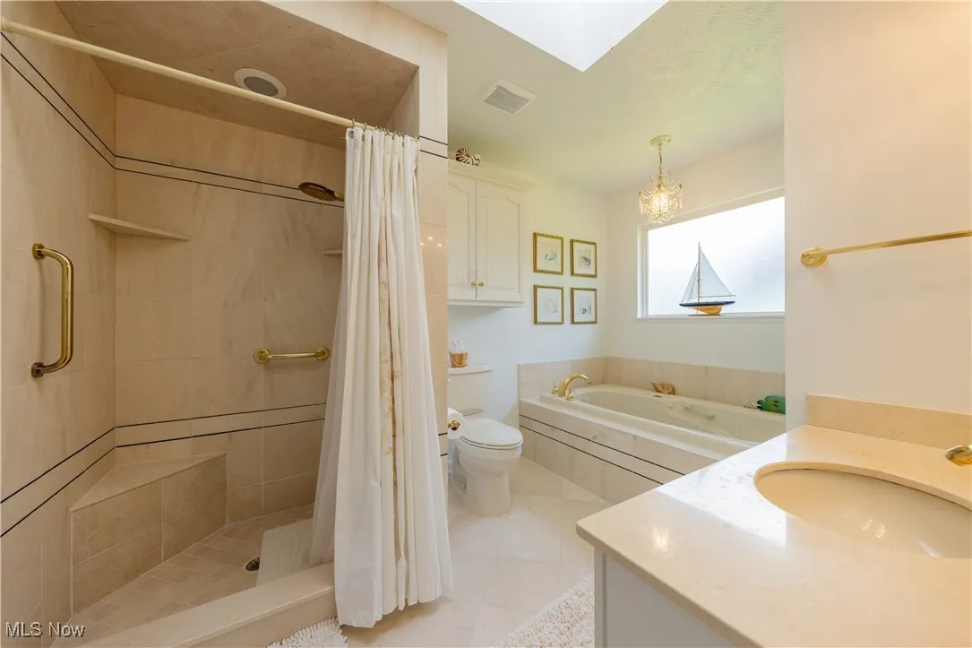 Bathroom with toilet, tiled shower, a garden tub, and tile patterned floors