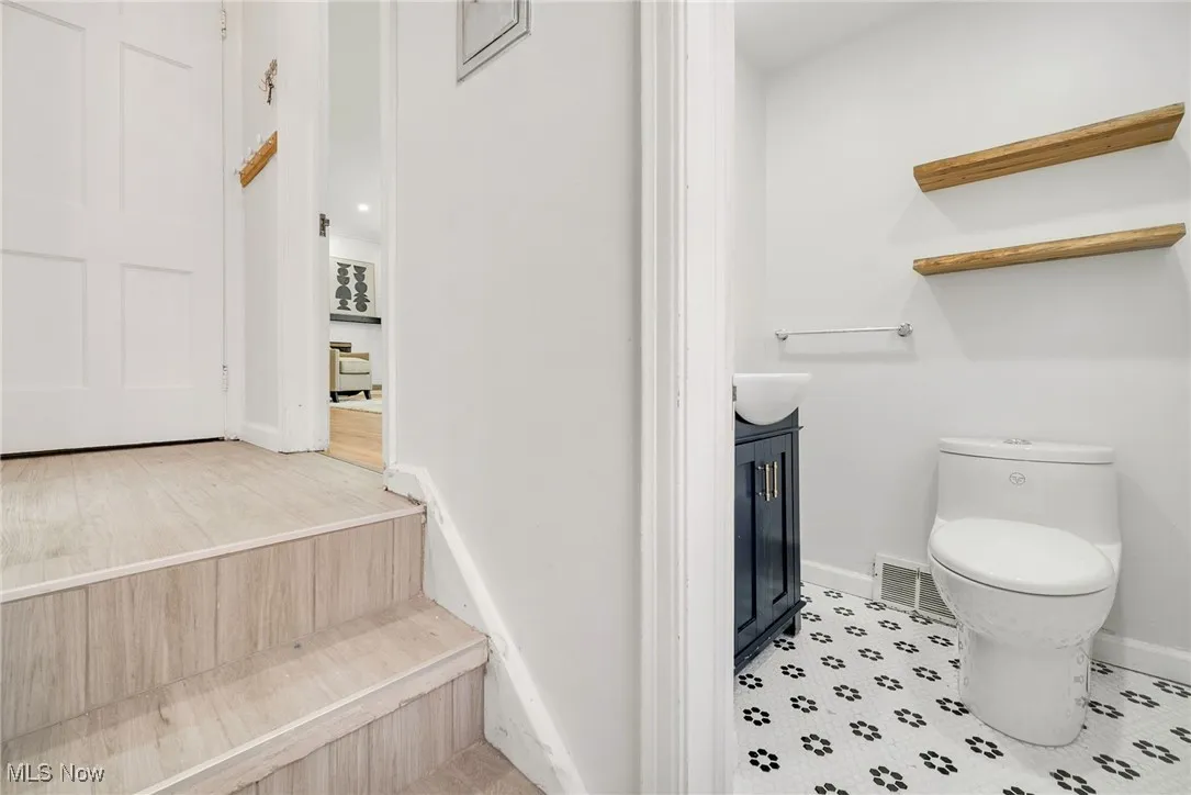 Bathroom featuring toilet, baseboards, and vanity