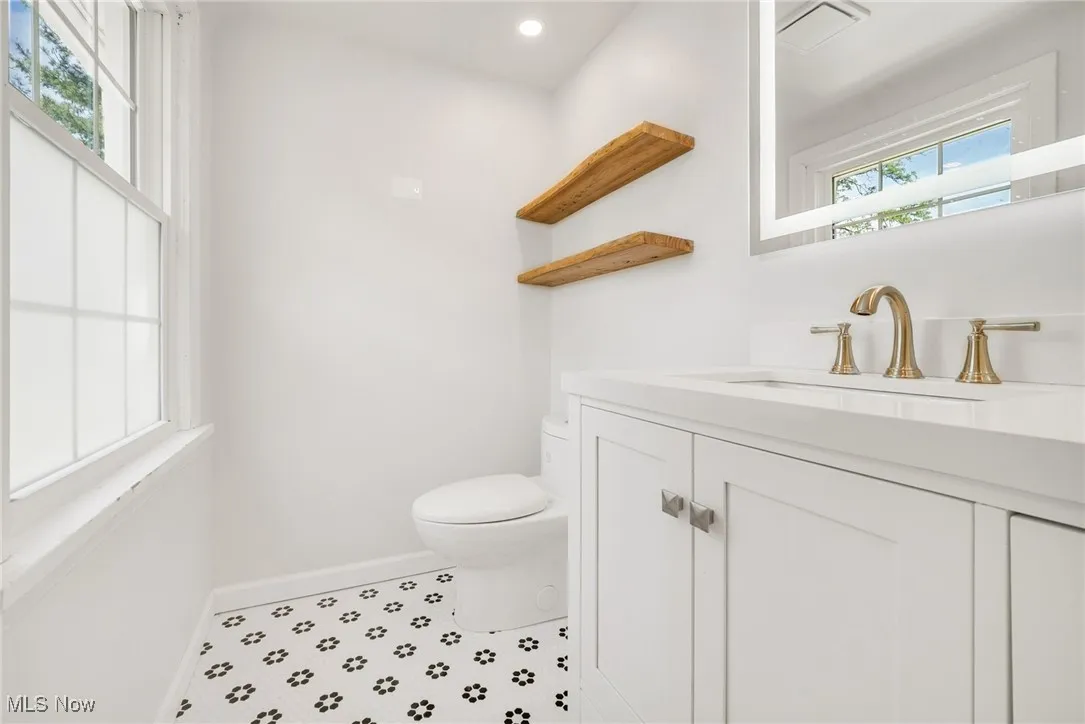 Bathroom featuring baseboards, toilet, vanity, recessed lighting, and tile patterned floors