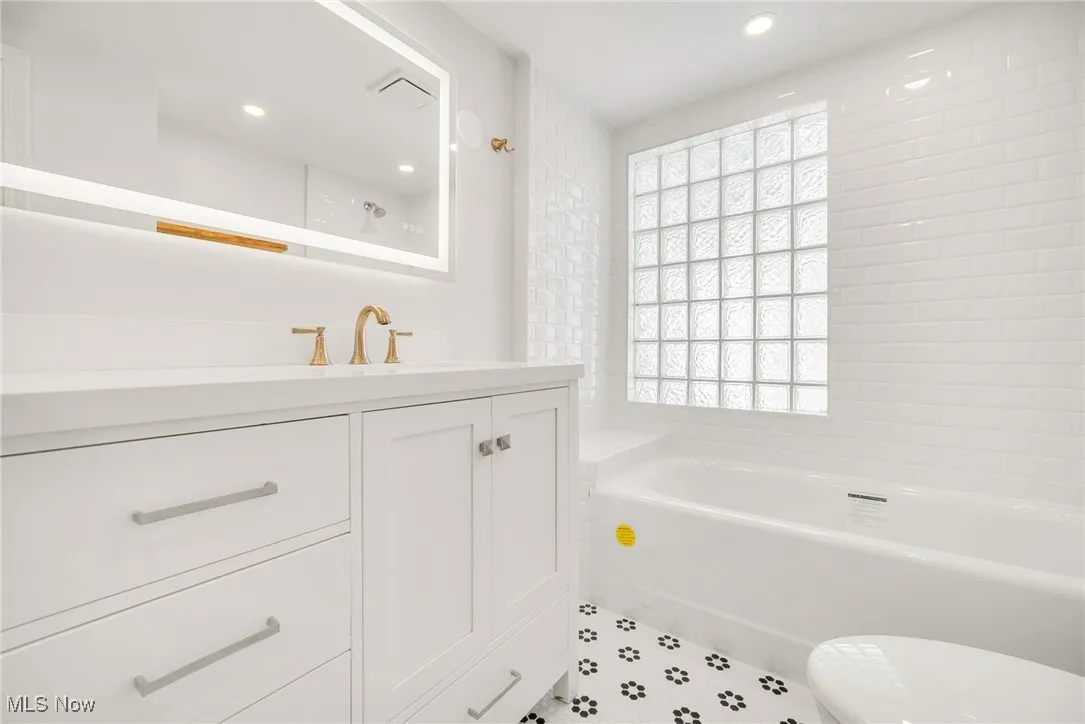 Full bath featuring a tub to relax in, vanity, recessed lighting, toilet, and a shower