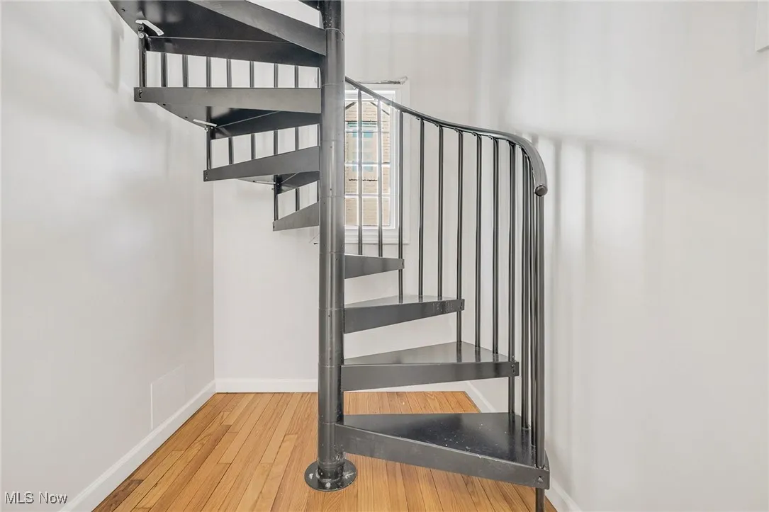 Staircase featuring wood finished floors and baseboards