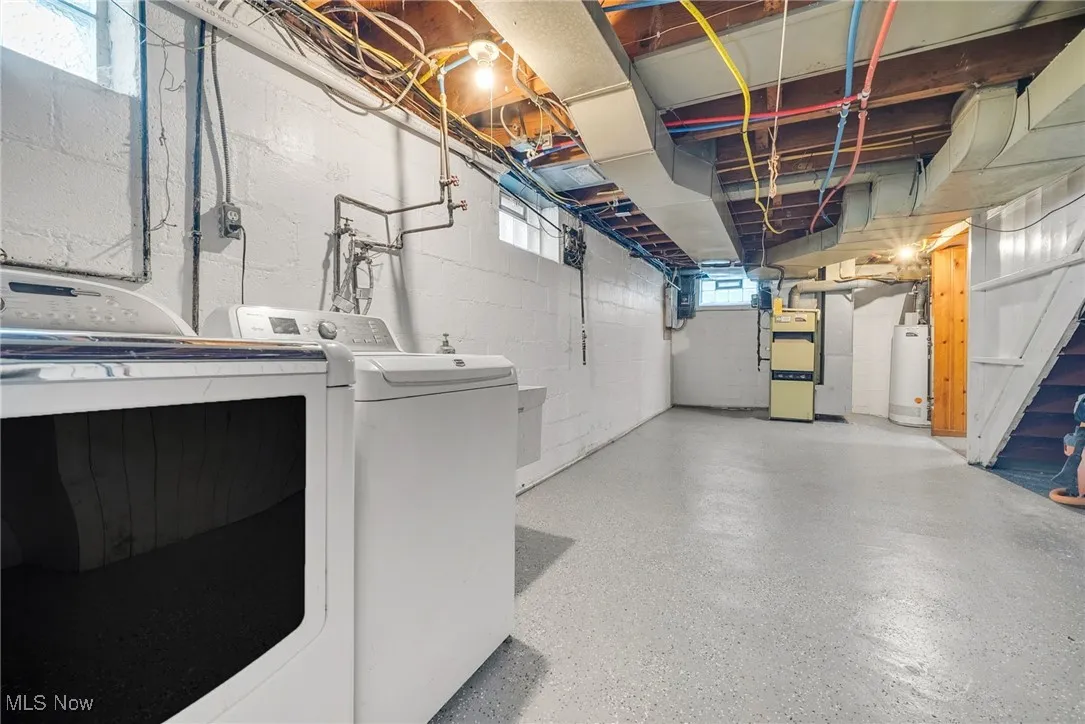 Below grade area featuring washer / clothes dryer, water heater, and heating unit