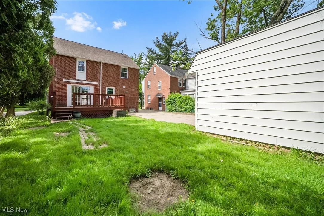 Back of property featuring a deck, a yard, and central AC unit