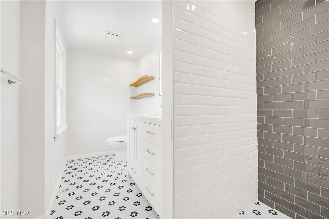 Bathroom featuring toilet, vanity, recessed lighting, baseboards, and tile patterned floors