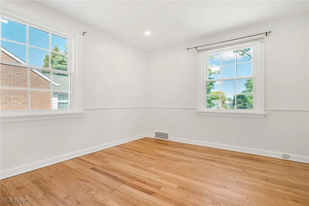 Unfurnished room with wood finished floors, baseboards, and recessed lighting