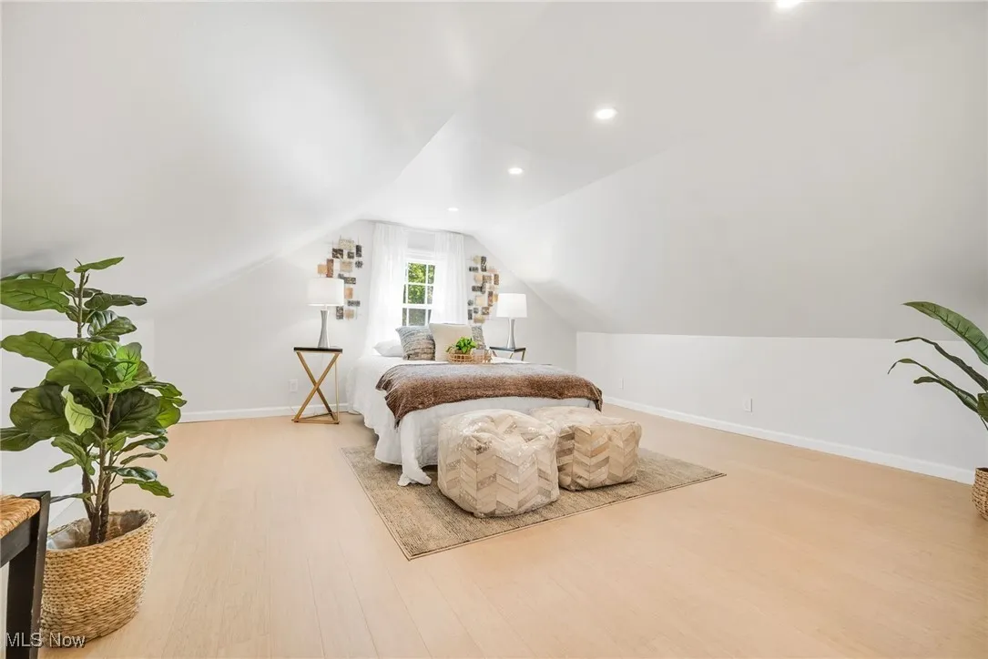 Bedroom with light wood-style floors, baseboards, lofted ceiling, and recessed lighting