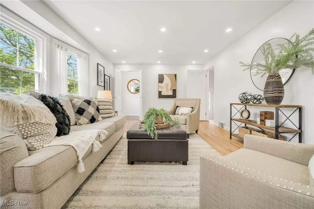Living area with light wood-style floors and recessed lighting