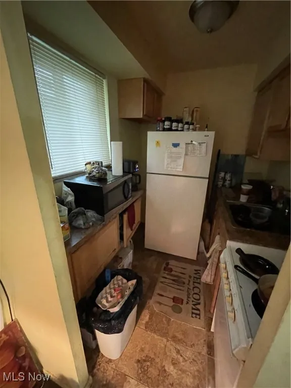 Kitchen featuring refrigerator, a sink, and range