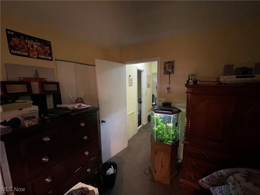 Bedroom with dark carpet and a closet