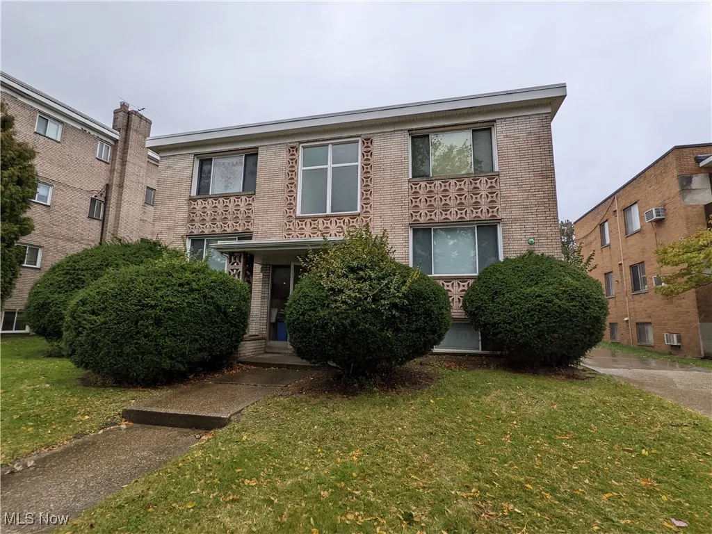 View of front facade featuring brick siding and a front lawn
