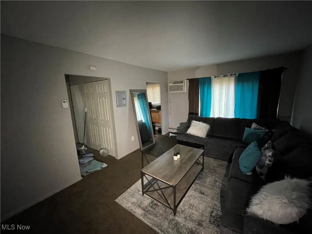 Living room with carpet and an AC wall unit