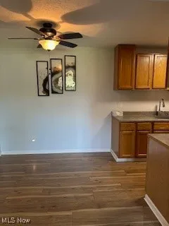 Kitchen featuring brown cabinets, baseboards, and ceiling fan
