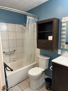 Bathroom featuring toilet, tile patterned flooring, vanity, shower / bath combo with shower curtain, and a textured ceiling