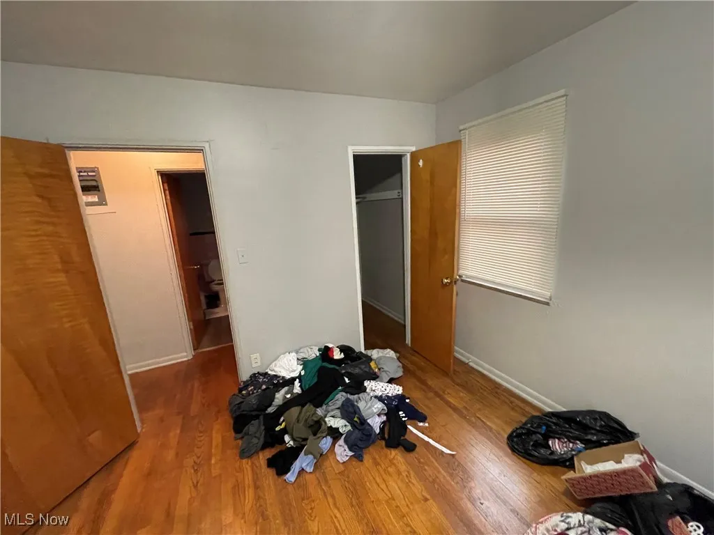 Unfurnished bedroom with wood finished floors and baseboards