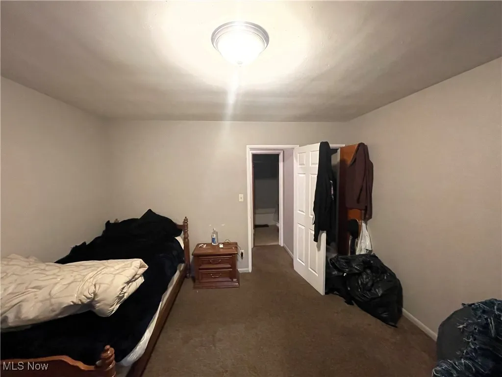 Bedroom featuring carpet and baseboards