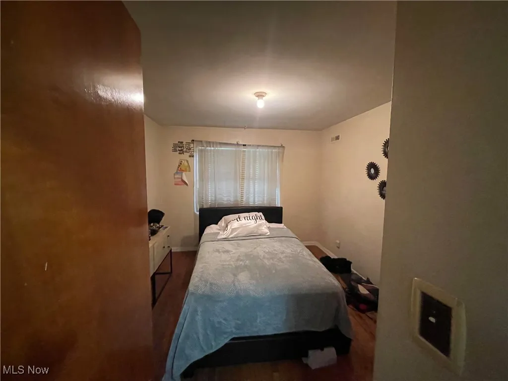 Bedroom featuring wood finished floors and baseboards