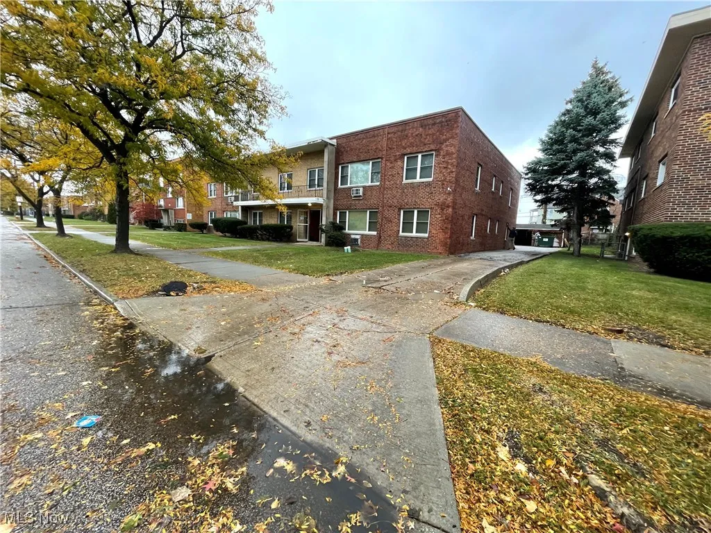 View of home's exterior featuring a lawn and brick siding