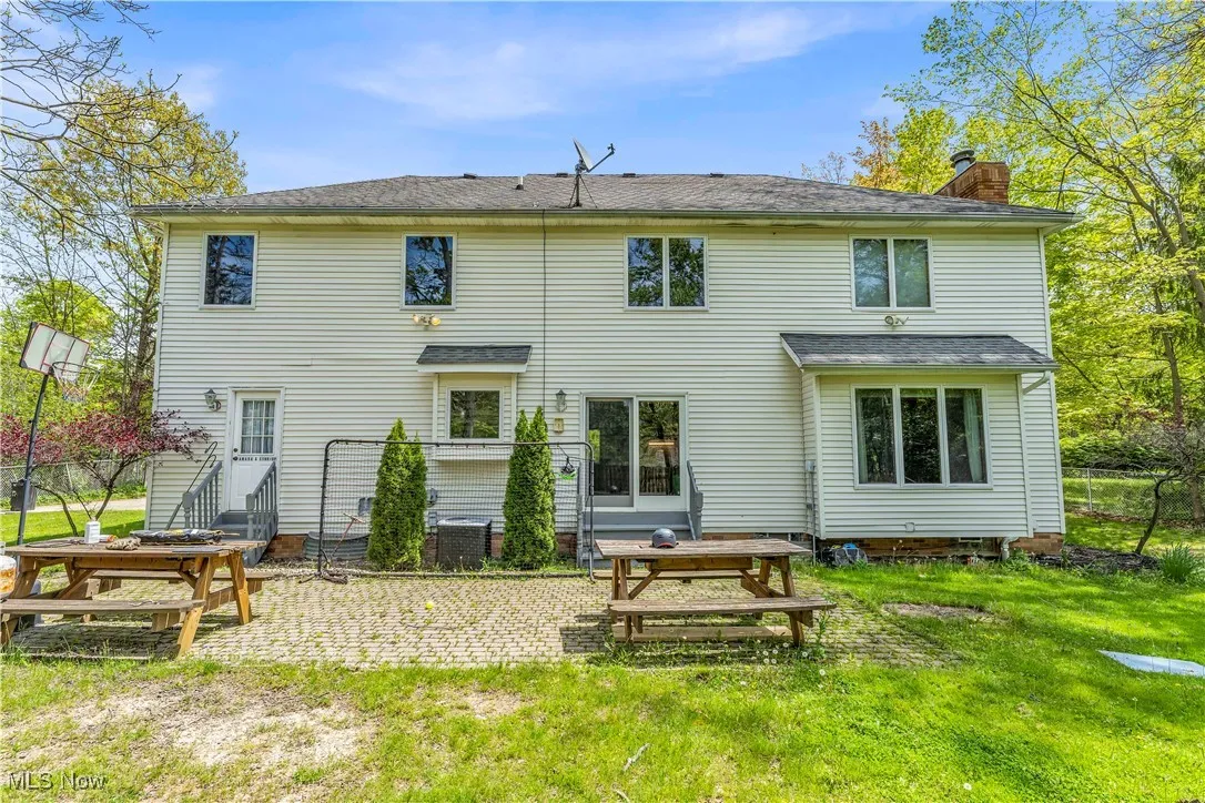 Back of property featuring a chimney, a patio area, and central air condition unit