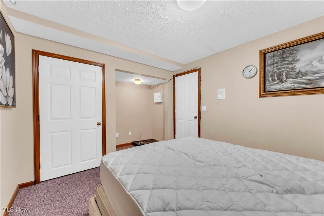 Bedroom with carpet floors, a textured ceiling, and baseboards
