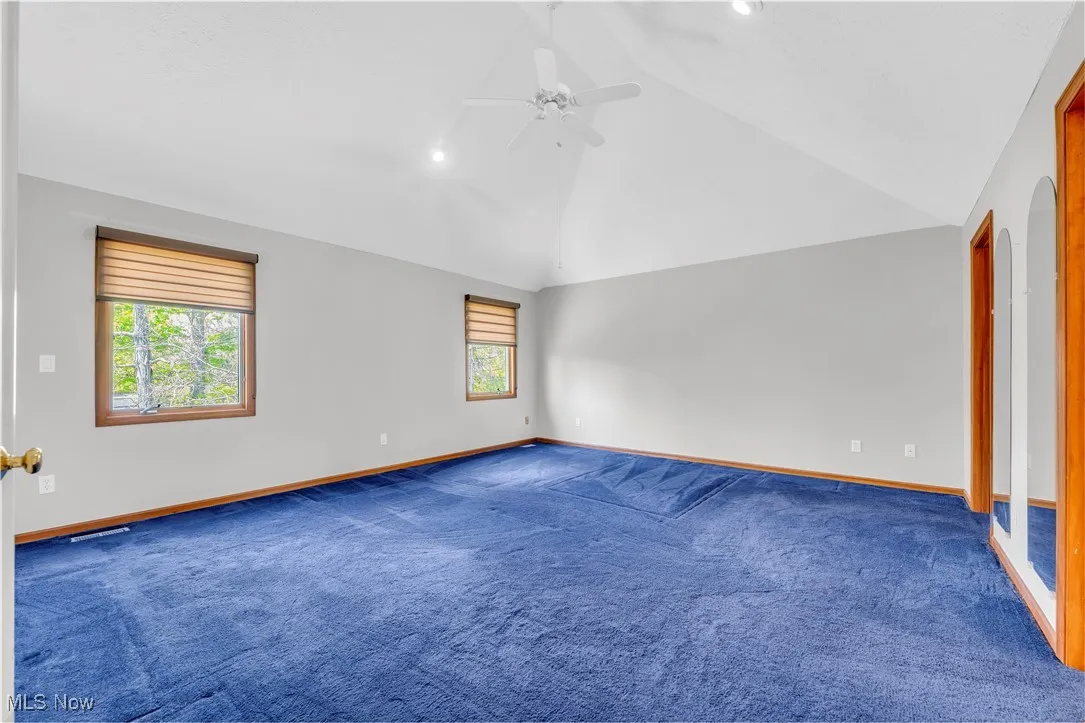 Spare room featuring vaulted ceiling, ceiling fan, baseboards, carpet floors, and recessed lighting
