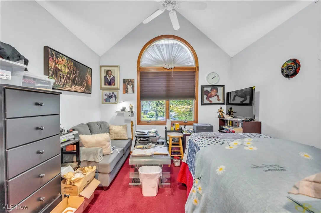 Bedroom with lofted ceiling, carpet flooring, and ceiling fan